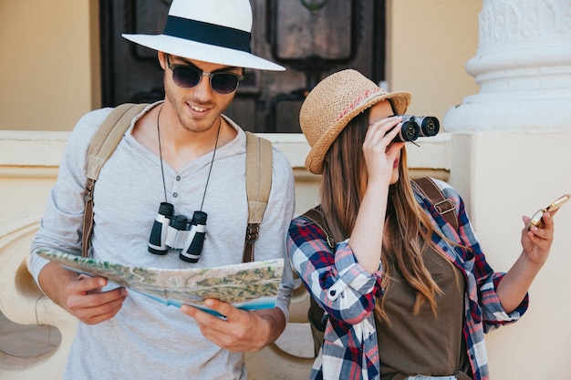 Viajeros perdidos con prismáticos, mapa y gafas de sol