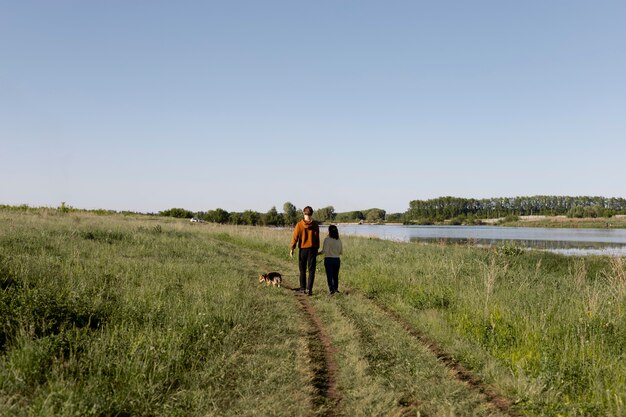 Viajeros de tiro largo con perro en la naturaleza