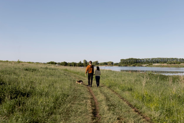 Viajeros de tiro largo con perro en la naturaleza