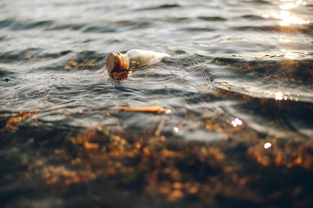 Vial de vidrio transparente en el cuerpo de agua.