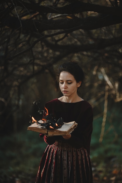 Foto gratuita las vibraciones del otoño. estilo gótico. mujer morena en paño rojo oscuro