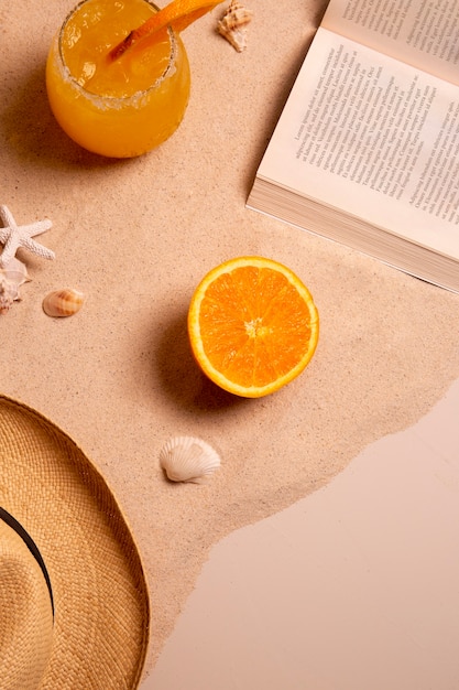 Vibraciones de verano con libro y sombrero en la arena.