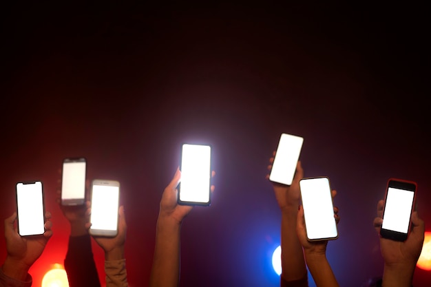 Vida nocturna de gente bailando en un club y sosteniendo teléfonos inteligentes.