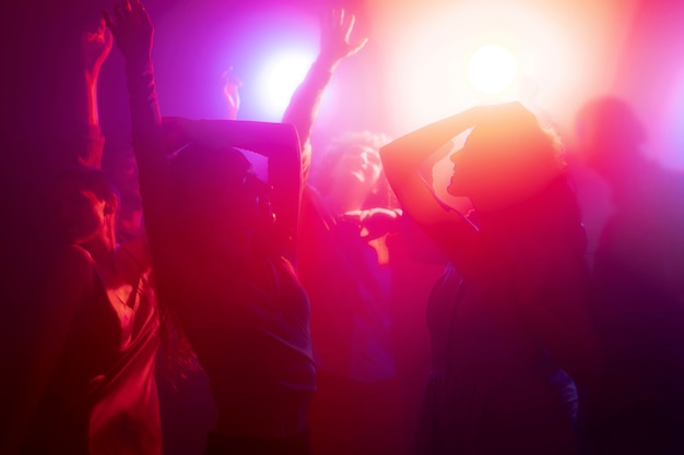 Vida nocturna con gente bailando en un club.