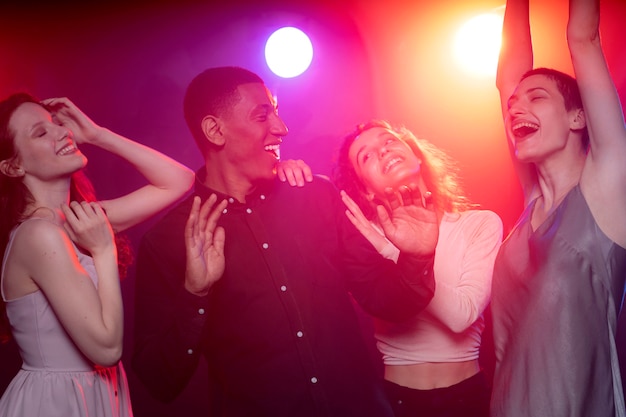 Vida nocturna con gente bailando en un club.