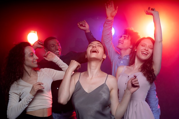 Vida nocturna con gente bailando en un club.