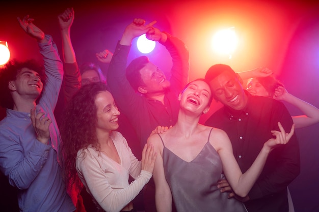 Vida nocturna con gente bailando en un club.