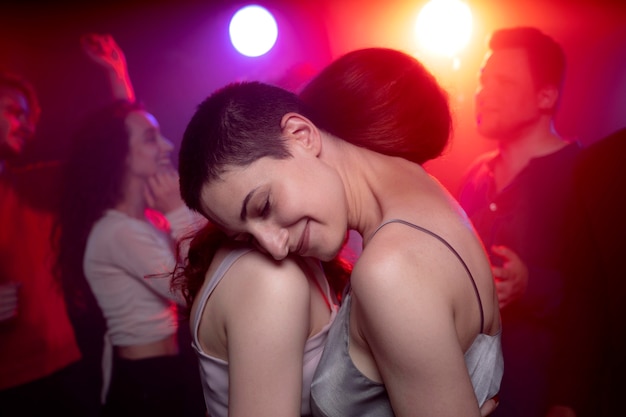 Vida nocturna con gente bailando en un club.