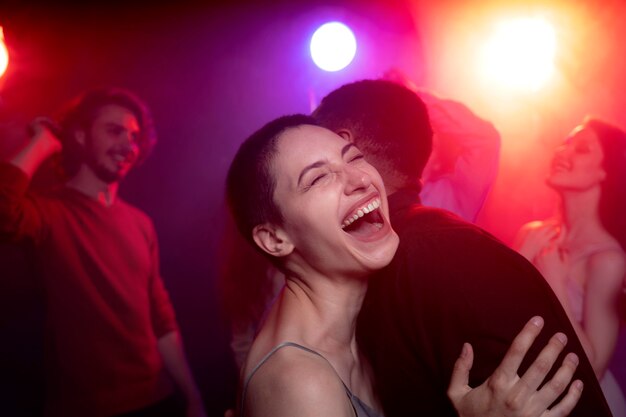 Vida nocturna con gente bailando en un club.