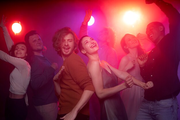 Vida nocturna con gente bailando en un club.