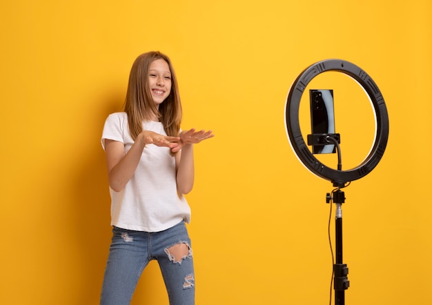 Foto gratuita video de grabación de adolescente sonriente de tiro medio