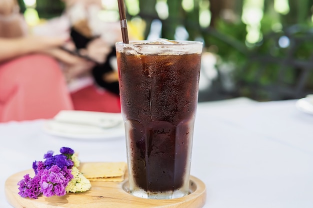 Vidrio americano frío en la mesa de cubierta de tela blanca - concepto de bebida fría y relajada