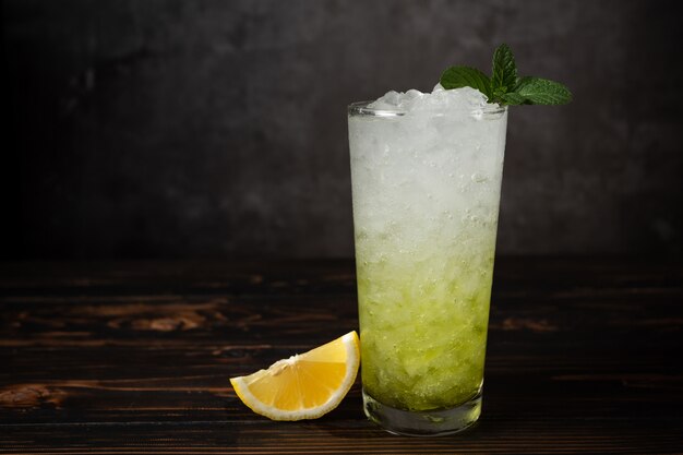 Vidrios de soda de limón con hielo y menta fresca en la tabla de madera.