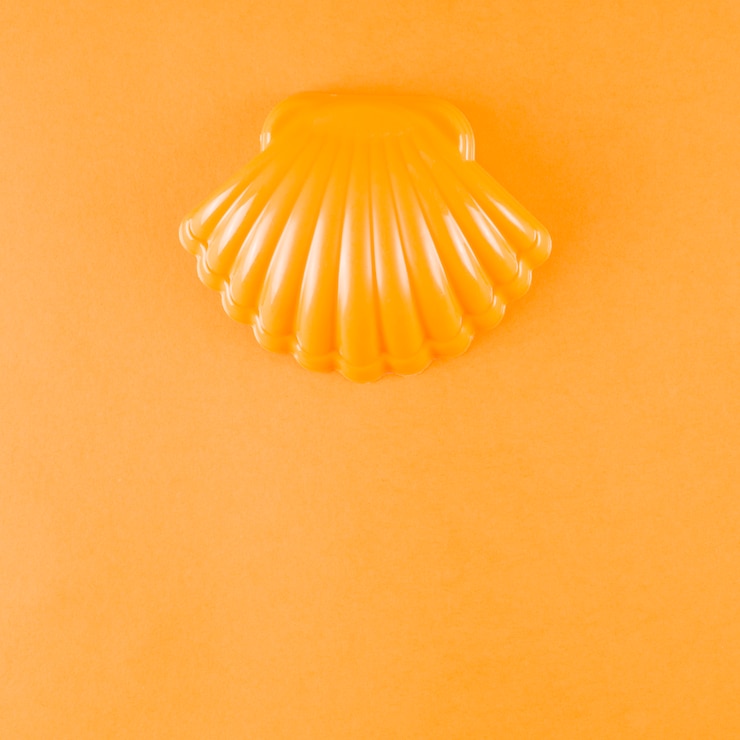 Foto gratuito vieira de plastico sobre un fondo naranja