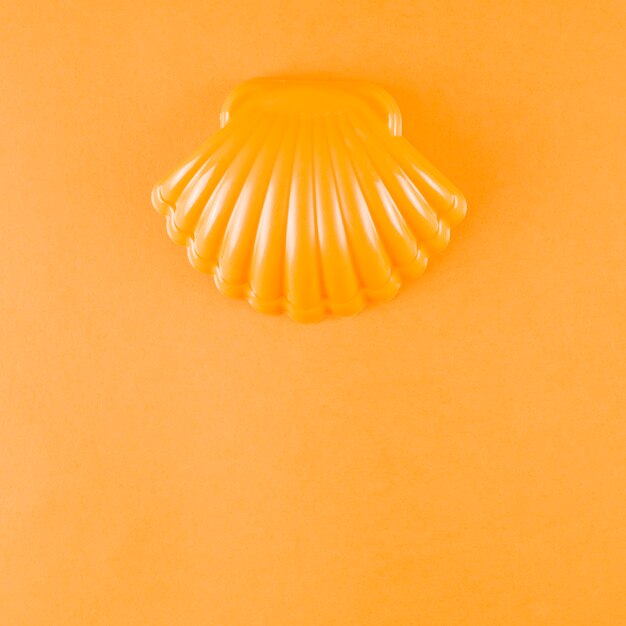 Vieira de plastico sobre un fondo naranja