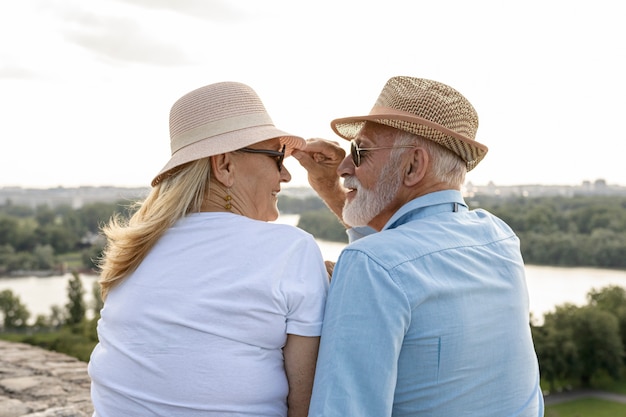 Viejo agarrando el sombrero de una mujer