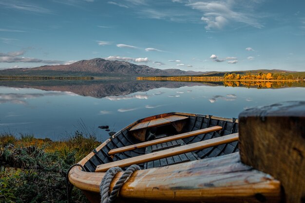 Viejo barco de madera en la orilla de un lago durante la puesta de sol