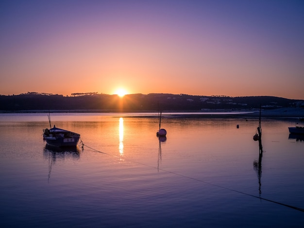 Viejo barco de pesca en el río con la impresionante vista de la puesta de sol