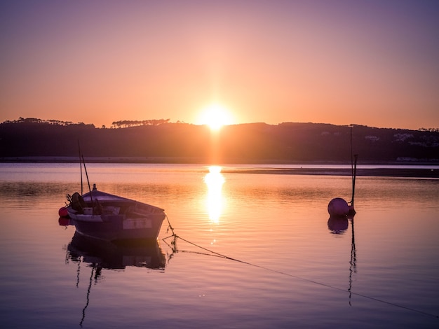 Viejo barco de pesca en el río con la impresionante vista de la puesta de sol