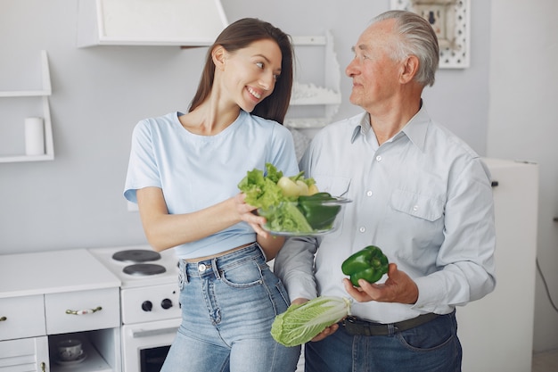 Viejo en una cocina con joven nieta