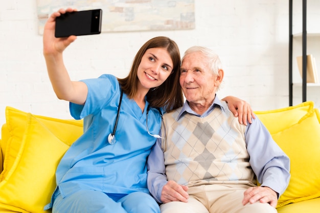 Viejo y enfermera tomando una selfie