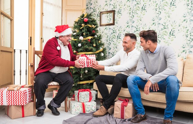 Viejo hombre dando caja de regalo al hombre