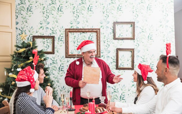 Viejo hombre leyendo de papel en la mesa festiva