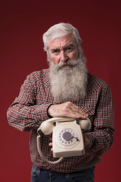 Foto gratuita viejo hombre sosteniendo un teléfono