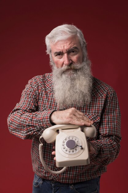 Viejo hombre sosteniendo un teléfono