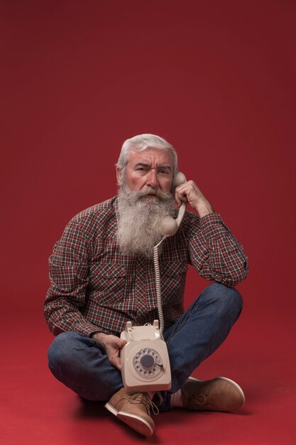 Viejo hombre sosteniendo un teléfono