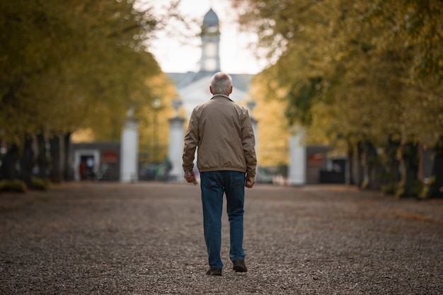 Viejo hombre de tiro completo dando un paseo