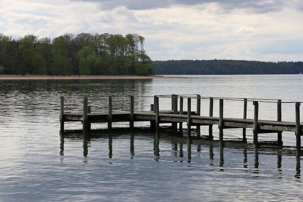 Viejo muelle oxidado por el lago rodeado de hermosos árboles en Middelfart, Dinamarca