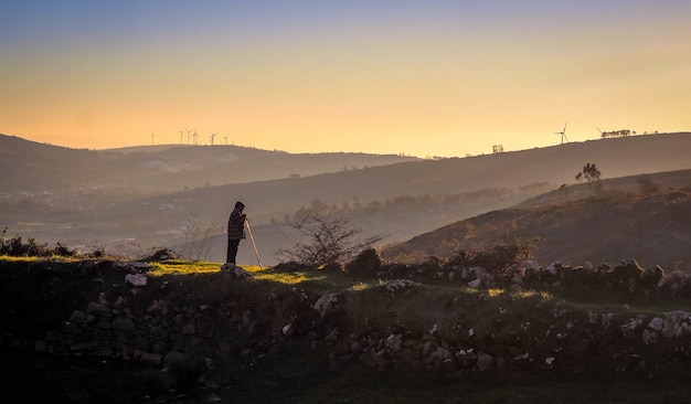 Foto gratuita viejo pastor mirando a las montañas al atardecer