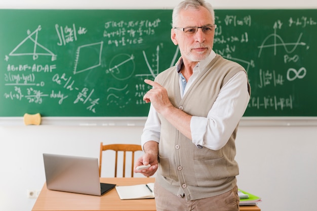 Viejo profesor mostrando en el aula