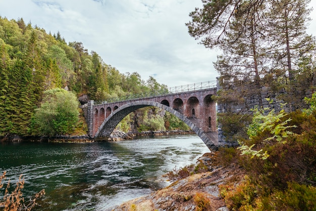 Viejo puente peatonal sobre el río cerca de Alesund; Noruega