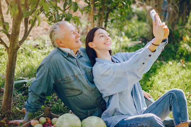 Viejo senior de pie en un jardín de verano con cosecha