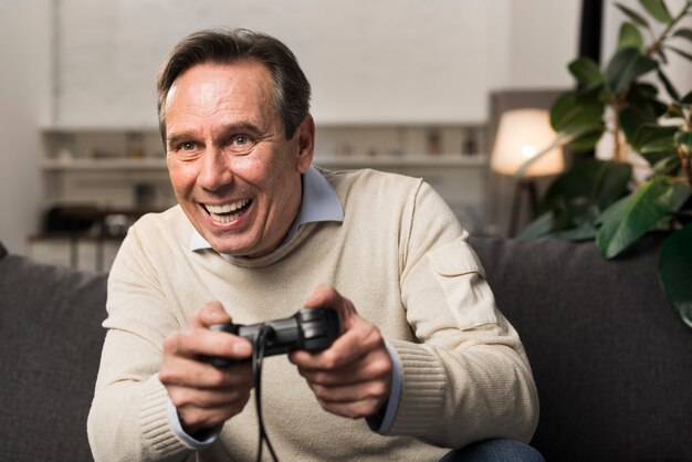 Viejo sonriendo y jugando videojuegos