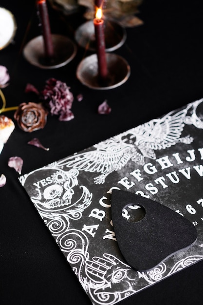 Foto gratuita viejo tablero de ouija de alto ángulo y velas