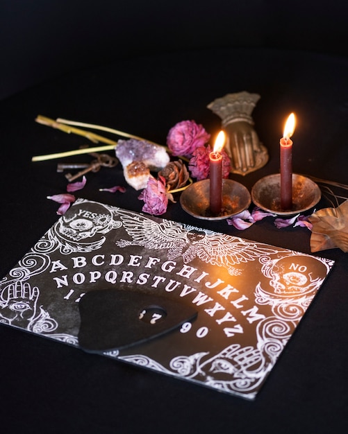 Viejo tablero de ouija de alto ángulo y velas