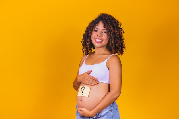 Vientre de una joven embarazada con una pegatina blanca y una pregunta (concepto de niño o niña). Foto Premium 