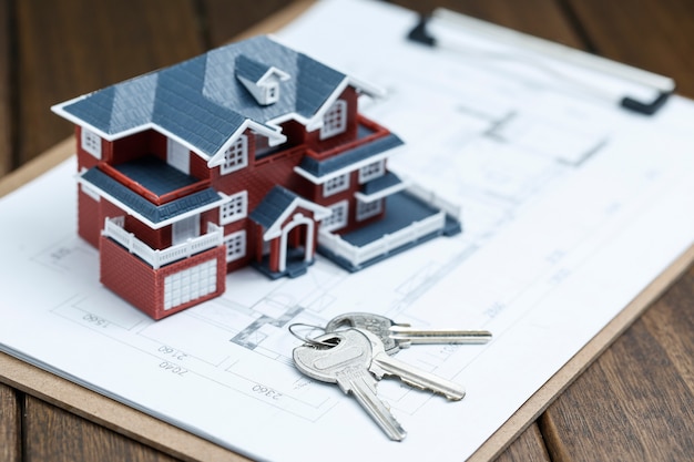 Villa modelo de la casa, la clave y el dibujo en el escritorio retro (concepto de venta de bienes raíces)