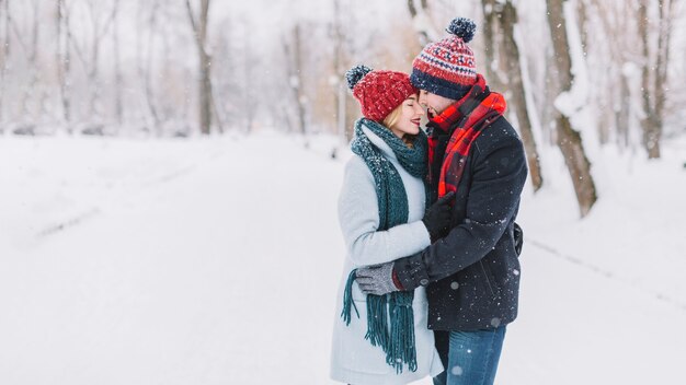 Vinculación joven pareja en el bosque de invierno