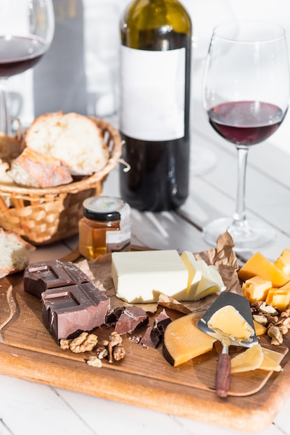 Vino, baguette y queso sobre fondo de madera