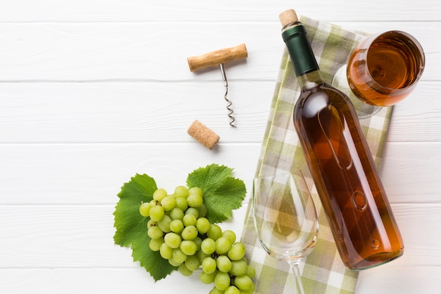 Foto gratuita vino blanco y copas sobre fondo de madera.