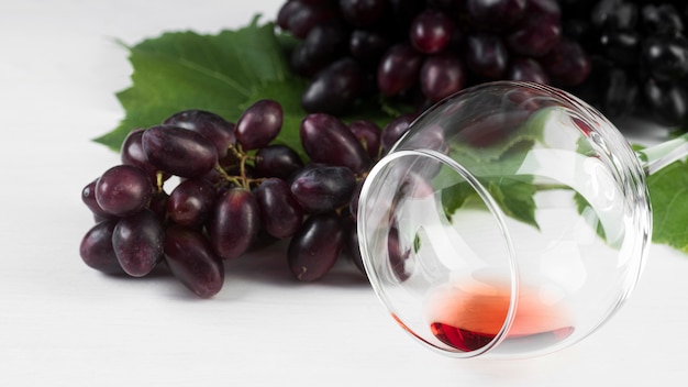 Foto gratuita vino de vista frontal en una copa y uvas