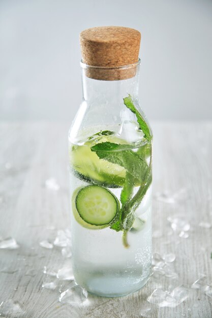 Vintage botella de vidrio llena de limonada de limón y menta fresca fría como mojito sin alcohol