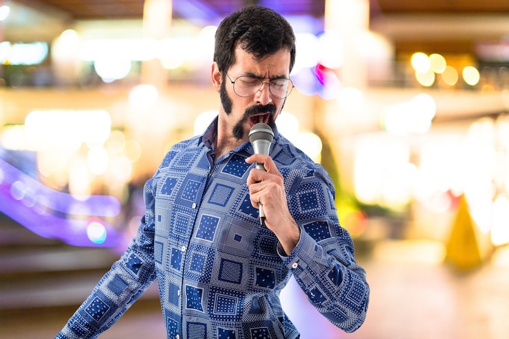 Foto gratuito vintage hombre joven cantando con micrófono