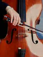 Foto gratuita violonchelista manos de jugador. violoncelista tocando el violoncelo en el fondo del campo. arte musical, concepto pasión en la música. la música clásica toca el violonchelo profesional solo