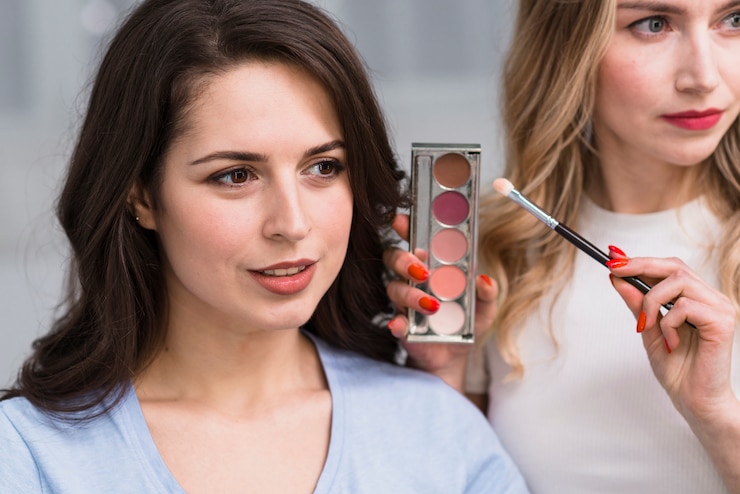 Foto gratuito visagiste mostrando la paleta de sombras de ojos.