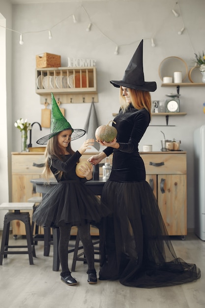 Víspera de Todos los Santos. Madre e hija disfrazadas de halloween. Familia en casa.